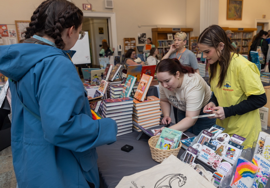filling out a form at a table at book fest