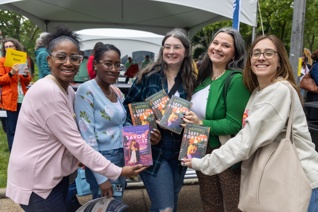 Attendees of 2025 Pgh Book Fest holding copies of books by the same author, Tarah Dewitt